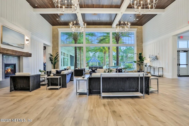 129 Oyster Shell Ter, Ponte Vedra, FL 32081 - living area with a chandelier, a towering ceiling, a glass covered fireplace, wood finished floors, and coffered ceiling