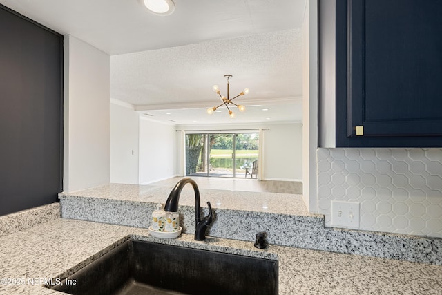 7855 La Sierra Ct Unit 7855, Jacksonville, FL 32256 - kitchen with ornamental molding, tasteful backsplash, a chandelier, light stone countertops, and blue cabinets