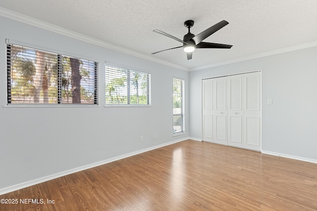 7855 La Sierra Ct Unit 7855, Jacksonville, FL 32256 - unfurnished bedroom featuring a textured ceiling, crown molding, light wood-style flooring, a closet, and ceiling fan