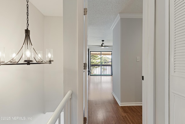 7855 La Sierra Ct Unit 7855, Jacksonville, FL 32256 - corridor featuring dark wood-style floors, an upstairs landing, a textured ceiling, a chandelier, and crown molding