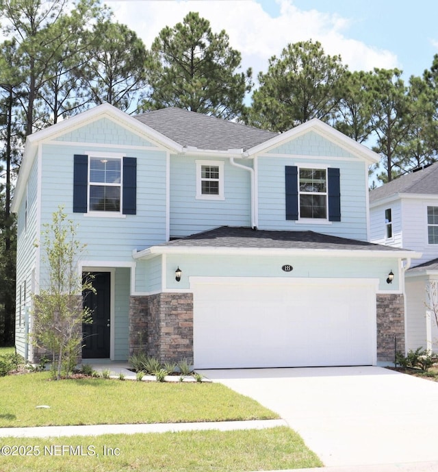 155 Gourd Island Way, Saint Johns, FL 32259 - view of front of property with an attached garage, stone siding, concrete driveway, a front yard, and roof with shingles