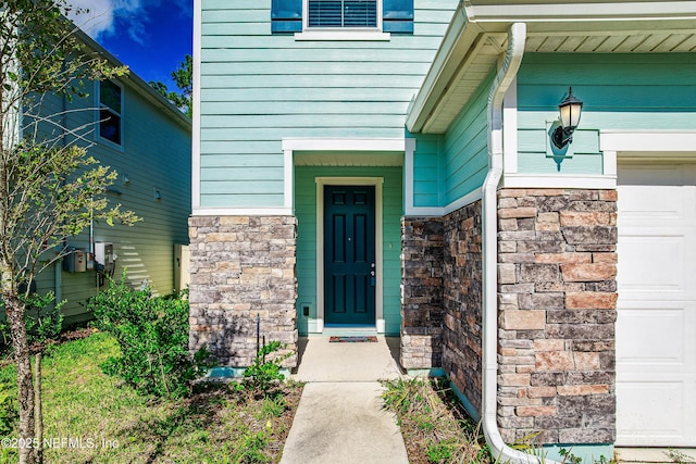 155 Gourd Island Way, Saint Johns, FL 32259 - doorway to property featuring stone siding and an attached garage