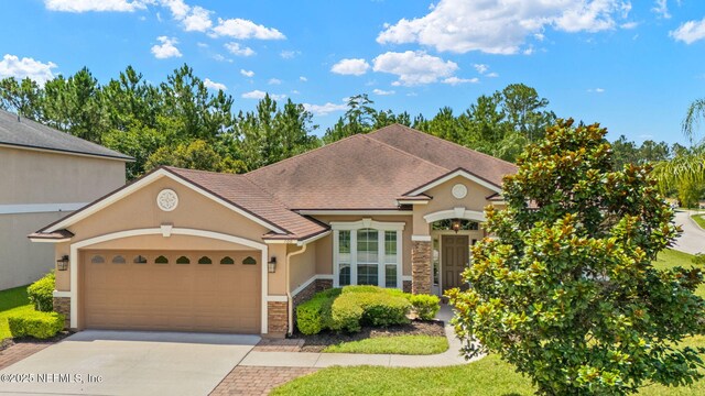 100 Cummer Way, Saint Augustine, FL 32095 - view of front facade featuring stone siding, a garage, concrete driveway, and stucco siding