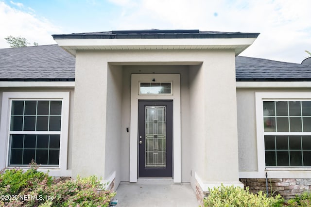 11115 Parkside Preserve Way, Jacksonville, FL 32257 - doorway to property featuring stucco siding, a shingled roof, and stone siding