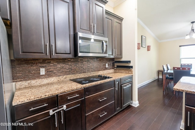 11115 Parkside Preserve Way, Jacksonville, FL 32257 - kitchen featuring stainless steel microwave, crown molding, black electric stovetop, backsplash, and dark brown cabinetry