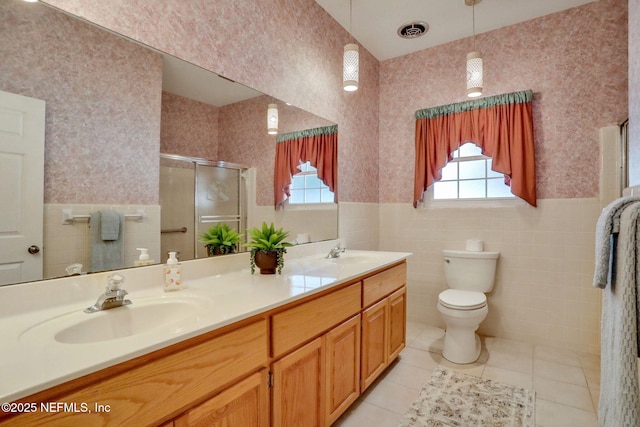 2785 Holly Point Rd E, Orange Park, FL 32073 - bathroom featuring a shower stall, a wainscoted wall, double vanity, tile walls, and tile patterned flooring