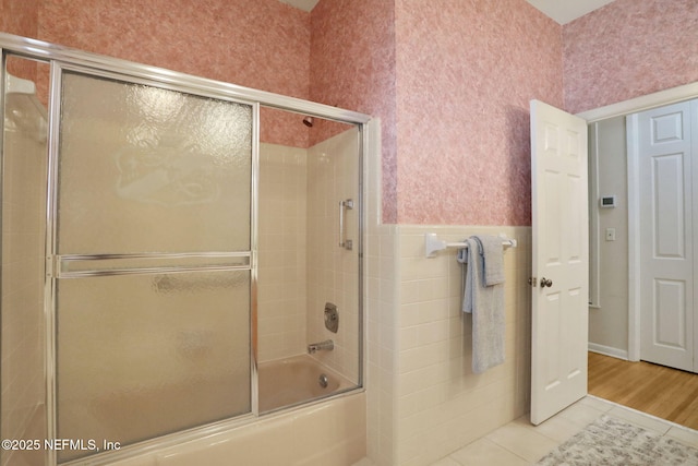 2785 Holly Point Rd E, Orange Park, FL 32073 - bathroom featuring tile patterned flooring, combined bath / shower with glass door, and wainscoting