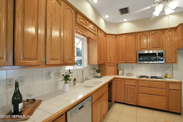 2785 Holly Point Rd E, Orange Park, FL 32073 - kitchen featuring stainless steel microwave, dishwashing machine, tile counters, tasteful backsplash, and ceiling fan