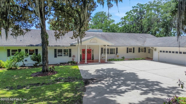 2785 Holly Point Rd E, Orange Park, FL 32073 - view of front of home with a front yard, roof with shingles, concrete driveway, and an attached garage