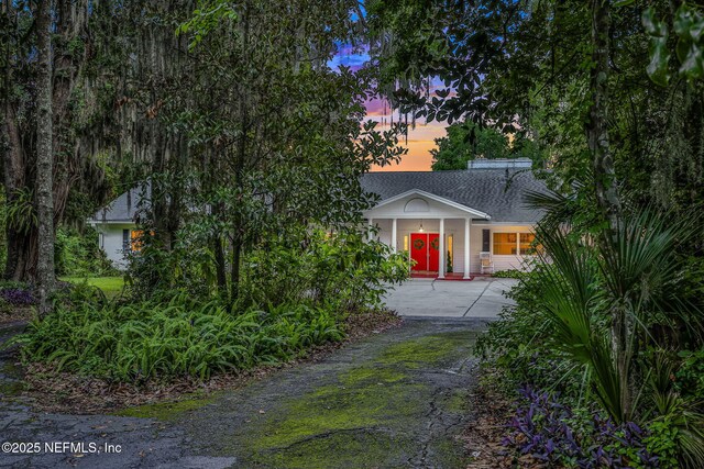 2785 Holly Point Rd E, Orange Park, FL 32073 - view of front of home featuring driveway, a shingled roof, and covered porch