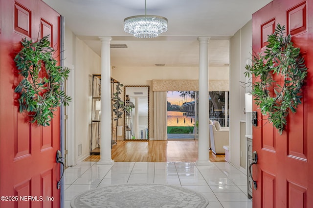 2785 Holly Point Rd E, Orange Park, FL 32073 - foyer entrance featuring decorative columns, light tile patterned floors, and a chandelier