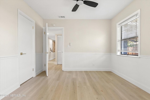 165 Sherry Dr, Atlantic Beach, FL 32233 - unfurnished bedroom featuring light wood finished floors, wainscoting, and ceiling fan