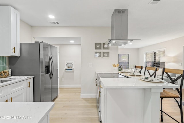 165 Sherry Dr, Atlantic Beach, FL 32233 - kitchen featuring stove, island range hood, a kitchen breakfast bar, a peninsula, and light wood-type flooring