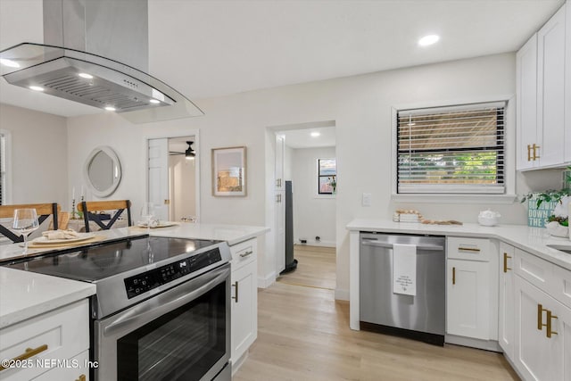 165 Sherry Dr, Atlantic Beach, FL 32233 - kitchen featuring appliances with stainless steel finishes, ventilation hood, light wood-style floors, white cabinetry, and recessed lighting
