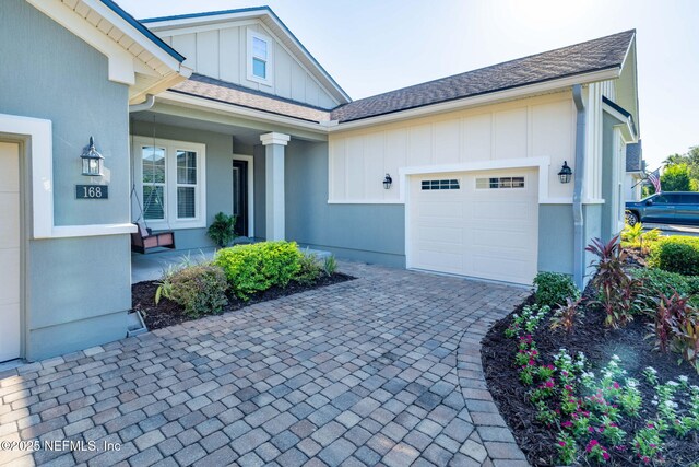 168 Bronson Pkwy, Saint Augustine, FL 32095 - view of front of home with a garage, board and batten siding, a porch, and decorative driveway