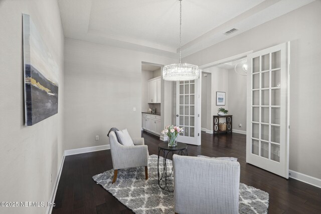 168 Bronson Pkwy, Saint Augustine, FL 32095 - living area featuring a chandelier, dark wood-style flooring, a raised ceiling, and french doors