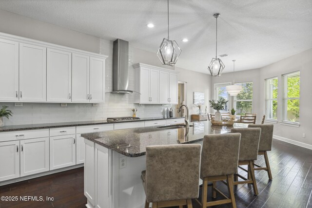 168 Bronson Pkwy, Saint Augustine, FL 32095 - kitchen featuring wall chimney range hood, tasteful backsplash, white cabinetry, dark wood-style floors, and recessed lighting