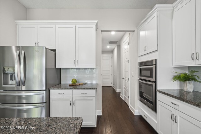168 Bronson Pkwy, Saint Augustine, FL 32095 - kitchen with appliances with stainless steel finishes, dark stone countertops, white cabinets, recessed lighting, and backsplash