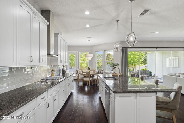 168 Bronson Pkwy, Saint Augustine, FL 32095 - kitchen featuring white cabinetry, backsplash, appliances with stainless steel finishes, a textured ceiling, and open floor plan