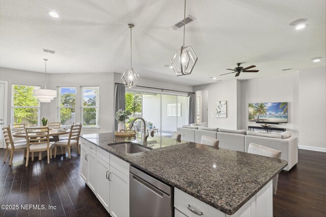 168 Bronson Pkwy, Saint Augustine, FL 32095 - kitchen featuring stainless steel dishwasher, a textured ceiling, dark wood-style flooring, ceiling fan, and an island with sink