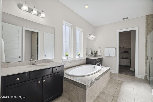 168 Bronson Pkwy, Saint Augustine, FL 32095 - full bathroom featuring vanity, a stall shower, a bath, a spacious closet, and tile patterned flooring
