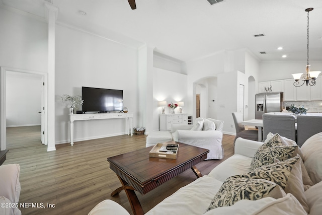 6105 Caladesi Ct, Jacksonville, FL 32258 - living area featuring arched walkways, a towering ceiling, a chandelier, wood finished floors, and crown molding