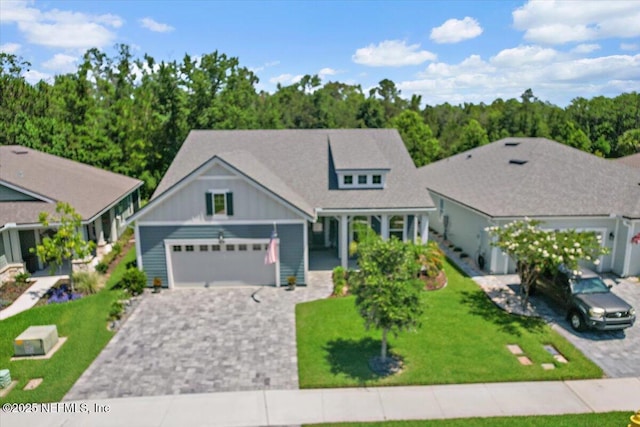 150 Calumet Dr, Saint Johns, FL 32259 - view of front of house featuring board and batten siding, decorative driveway, an attached garage, and a front yard