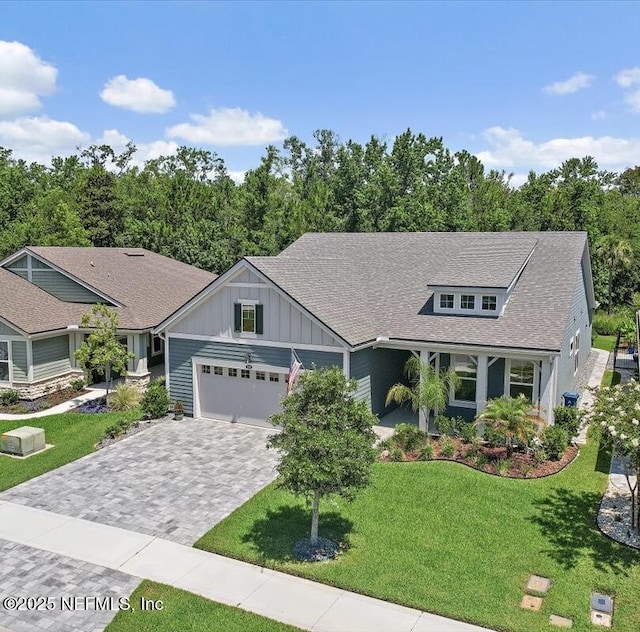150 Calumet Dr, Saint Johns, FL 32259 - view of front of property featuring board and batten siding, decorative driveway, an attached garage, a front yard, and roof with shingles