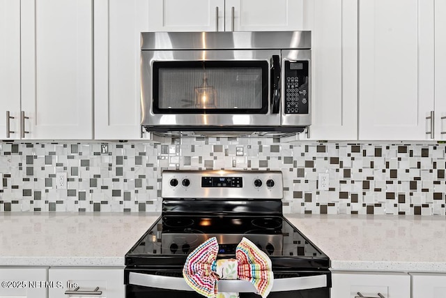 20 Evansville Ln, Palm Coast, FL 32164 - kitchen with appliances with stainless steel finishes, backsplash, white cabinets, and light stone counters