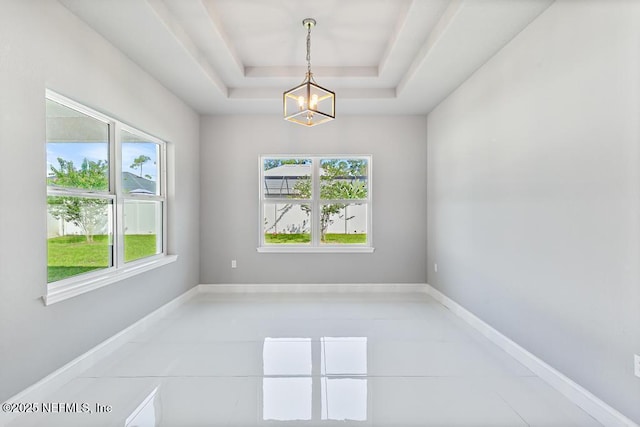 20 Evansville Ln, Palm Coast, FL 32164 - unfurnished room with a chandelier, light tile patterned floors, and a tray ceiling