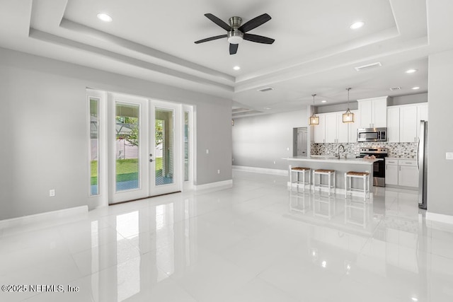 20 Evansville Ln, Palm Coast, FL 32164 - living room with a tray ceiling, ceiling fan, recessed lighting, light tile patterned floors, and french doors