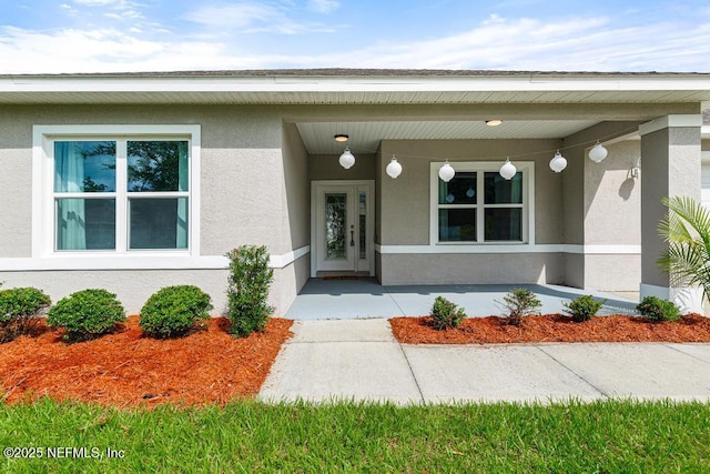 20 Evansville Ln, Palm Coast, FL 32164 - doorway to property with stucco siding and covered porch