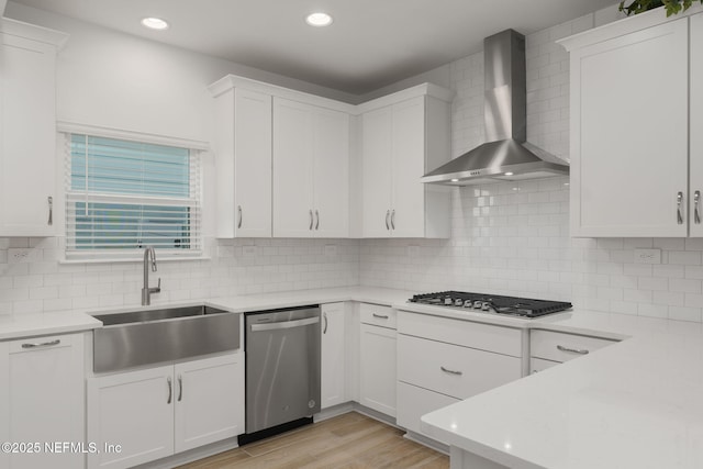 174 Torres Trce, Saint Augustine, FL 32095 - kitchen with wall chimney exhaust hood, stainless steel appliances, light countertops, white cabinetry, and decorative backsplash