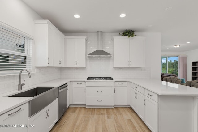 174 Torres Trce, Saint Augustine, FL 32095 - kitchen featuring wall chimney exhaust hood, stainless steel dishwasher, gas stovetop, a peninsula, and light countertops