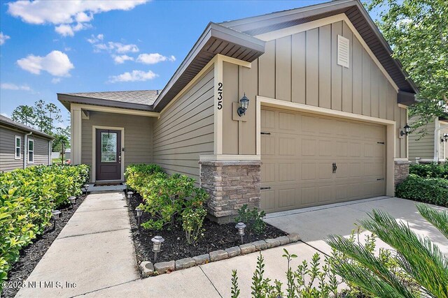 235 Brybar Dr, Saint Augustine, FL 32095 - view of front facade with stone siding, board and batten siding, a garage, and concrete driveway
