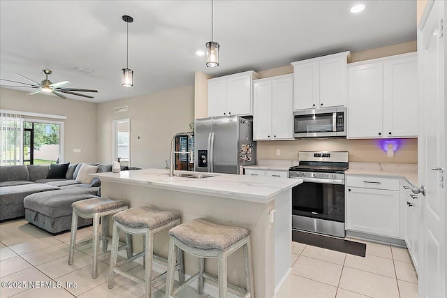 235 Brybar Dr, Saint Augustine, FL 32095 - kitchen with stainless steel appliances, open floor plan, light tile patterned floors, a breakfast bar, and white cabinetry