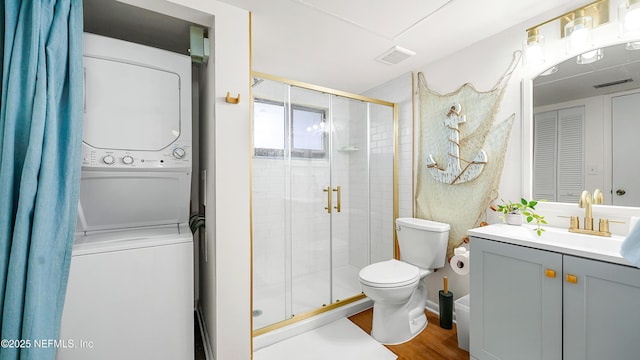 4250 A1A Unit B16, Saint Augustine, FL 32080 - full bath featuring stacked washer and clothes dryer, a stall shower, vanity, and wood finished floors
