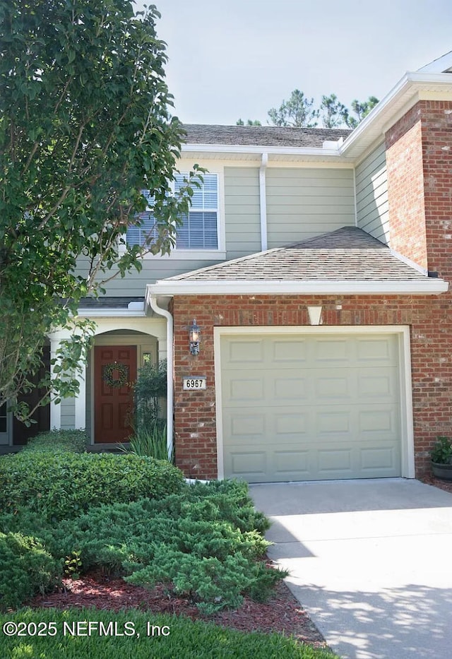 6967 Roundleaf Dr, Jacksonville, FL 32258 - view of front of property featuring concrete driveway, an attached garage, brick siding, and roof with shingles