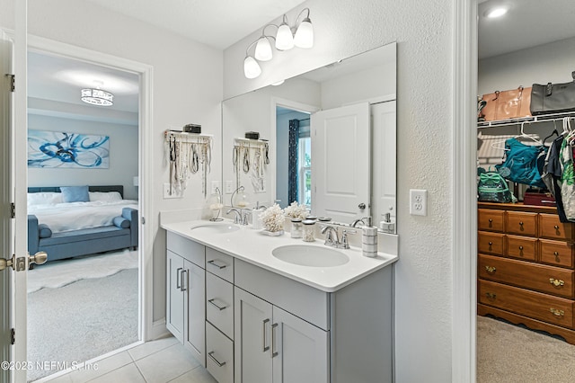 105 Meadow Creek Dr, Saint Johns, FL 32259 - bathroom with double vanity, ensuite bathroom, a spacious closet, and tile patterned floors