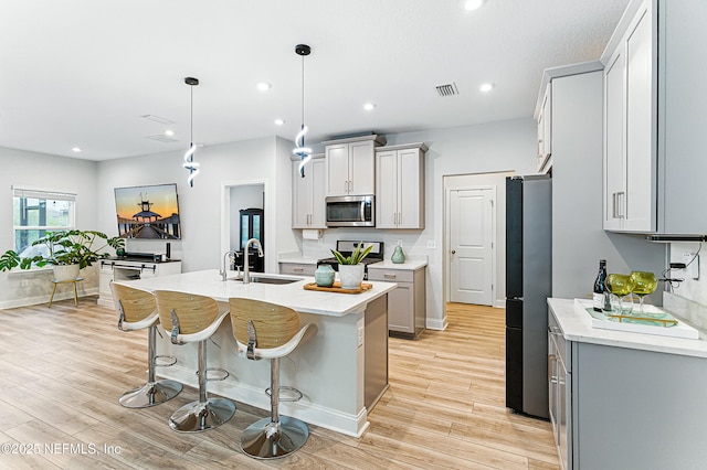 105 Meadow Creek Dr, Saint Johns, FL 32259 - kitchen with stainless steel microwave, freestanding refrigerator, light wood-style flooring, light countertops, and recessed lighting