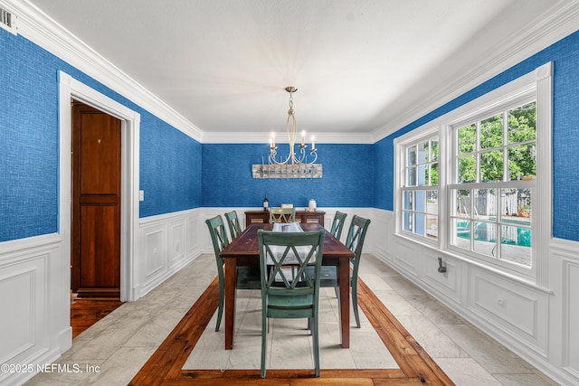 3679 Rustic Ln, Jacksonville, FL 32217 - dining room featuring a chandelier, crown molding, wainscoting, and a decorative wall