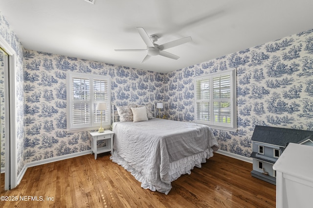 3679 Rustic Ln, Jacksonville, FL 32217 - bedroom featuring wood finished floors, wallpapered walls, multiple windows, and a ceiling fan