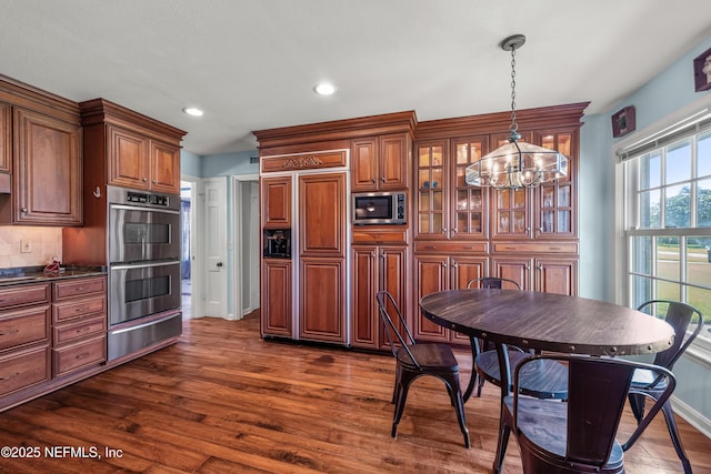 3679 Rustic Ln, Jacksonville, FL 32217 - kitchen with a warming drawer, appliances with stainless steel finishes, dark countertops, a chandelier, and dark wood finished floors
