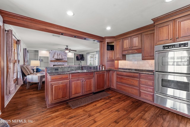 3679 Rustic Ln, Jacksonville, FL 32217 - kitchen featuring double oven, a ceiling fan, a fireplace, a warming drawer, and open floor plan