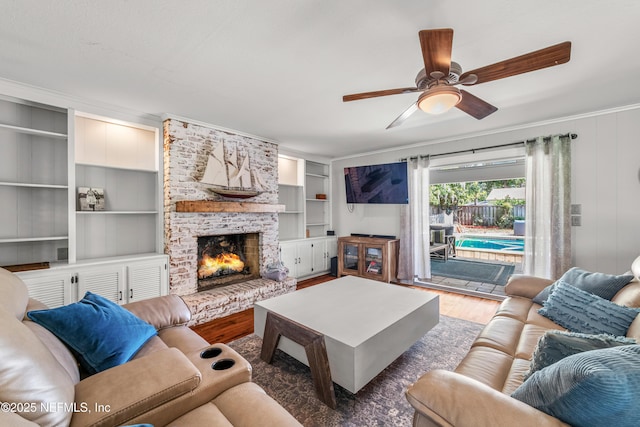 3679 Rustic Ln, Jacksonville, FL 32217 - living room featuring wood finished floors, a ceiling fan, a large fireplace, and ornamental molding