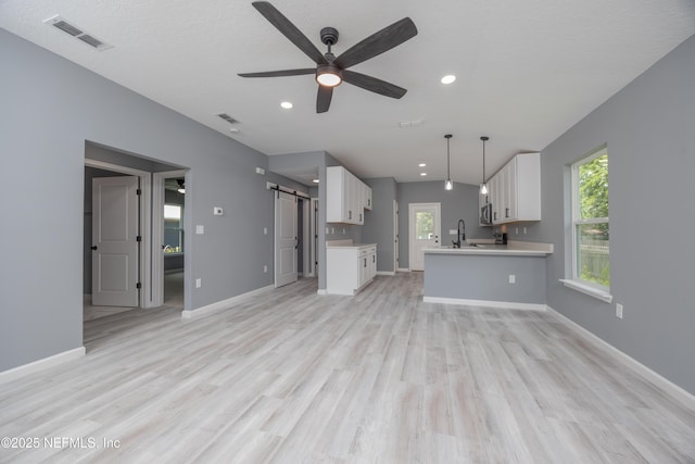 460 S Nassau St, Saint Augustine, FL 32084 - unfurnished living room featuring a barn door, ceiling fan, light wood-style flooring, and recessed lighting