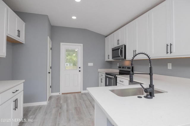 460 S Nassau St, Saint Augustine, FL 32084 - kitchen featuring appliances with stainless steel finishes, light wood-type flooring, light countertops, recessed lighting, and lofted ceiling