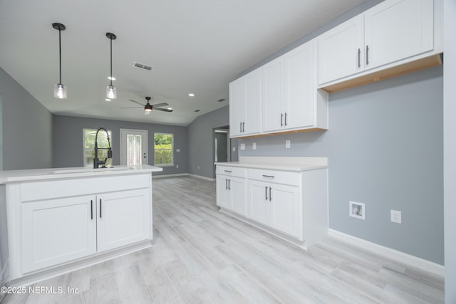 460 S Nassau St, Saint Augustine, FL 32084 - kitchen with a ceiling fan, hanging light fixtures, light wood finished floors, white cabinetry, and lofted ceiling