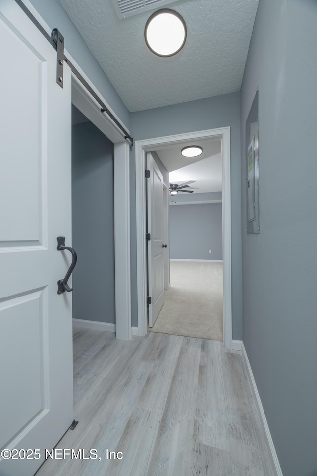 460 S Nassau St, Saint Augustine, FL 32084 - hallway with a barn door, wood finished floors, and a textured ceiling