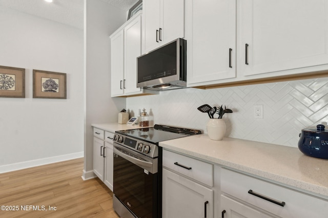 85448 Sandy Ridge Loop Unit 0049, Yulee, FL 32097 - kitchen with stainless steel appliances, decorative backsplash, white cabinets, light wood finished floors, and light stone counters